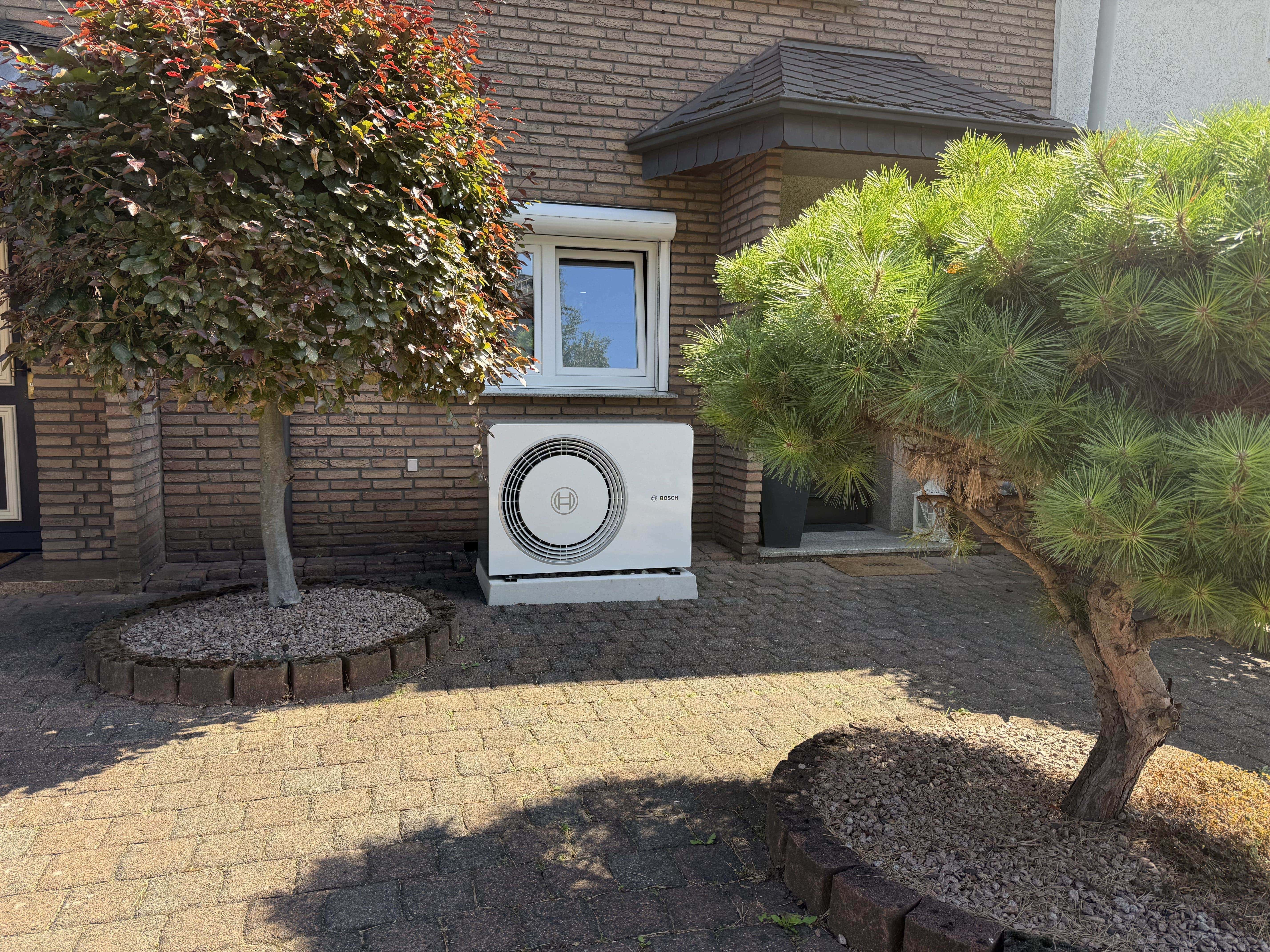 Bosch-Wärmepumpe im Vorgarten eines Einfamilienhauses
